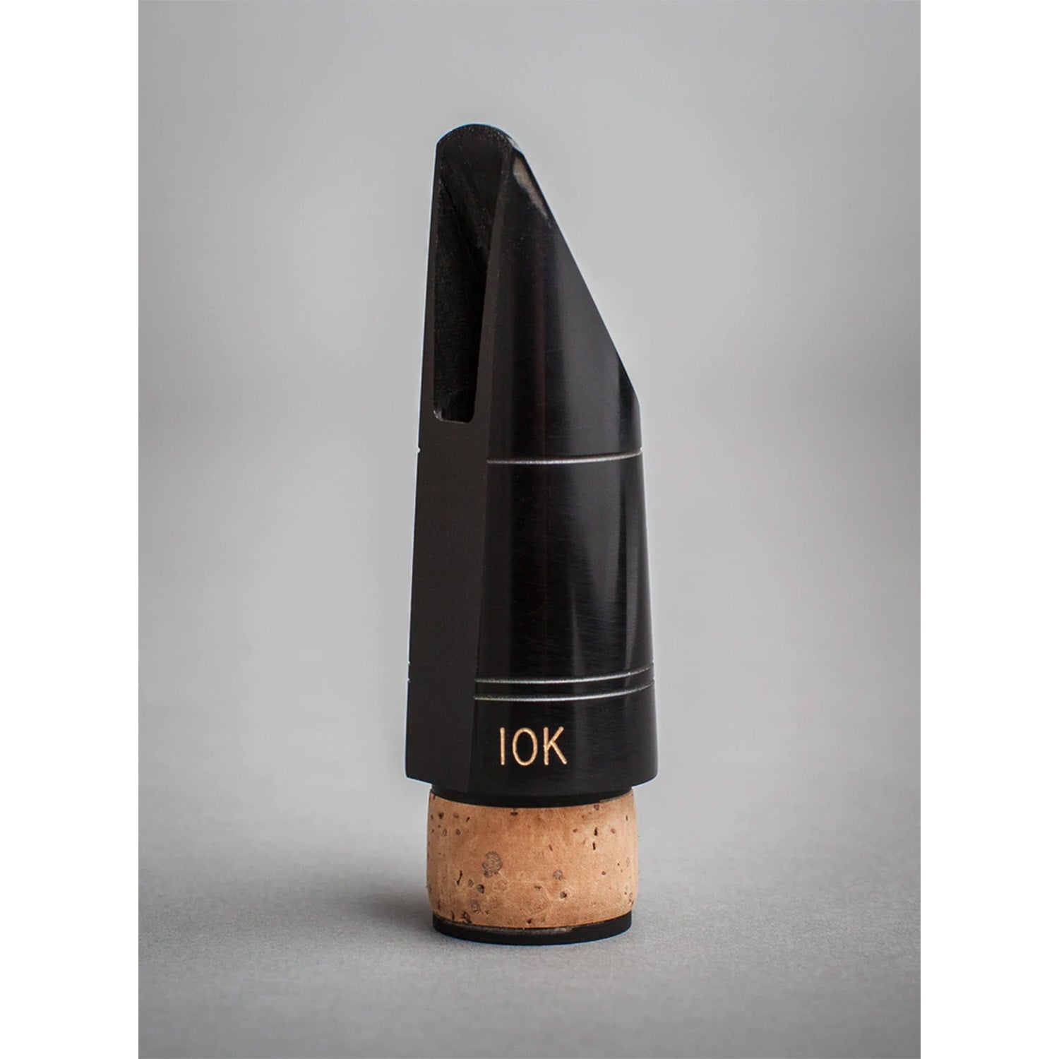 Three-quarters side view of black Fobes 10k Bb mouthpiece on a gray background