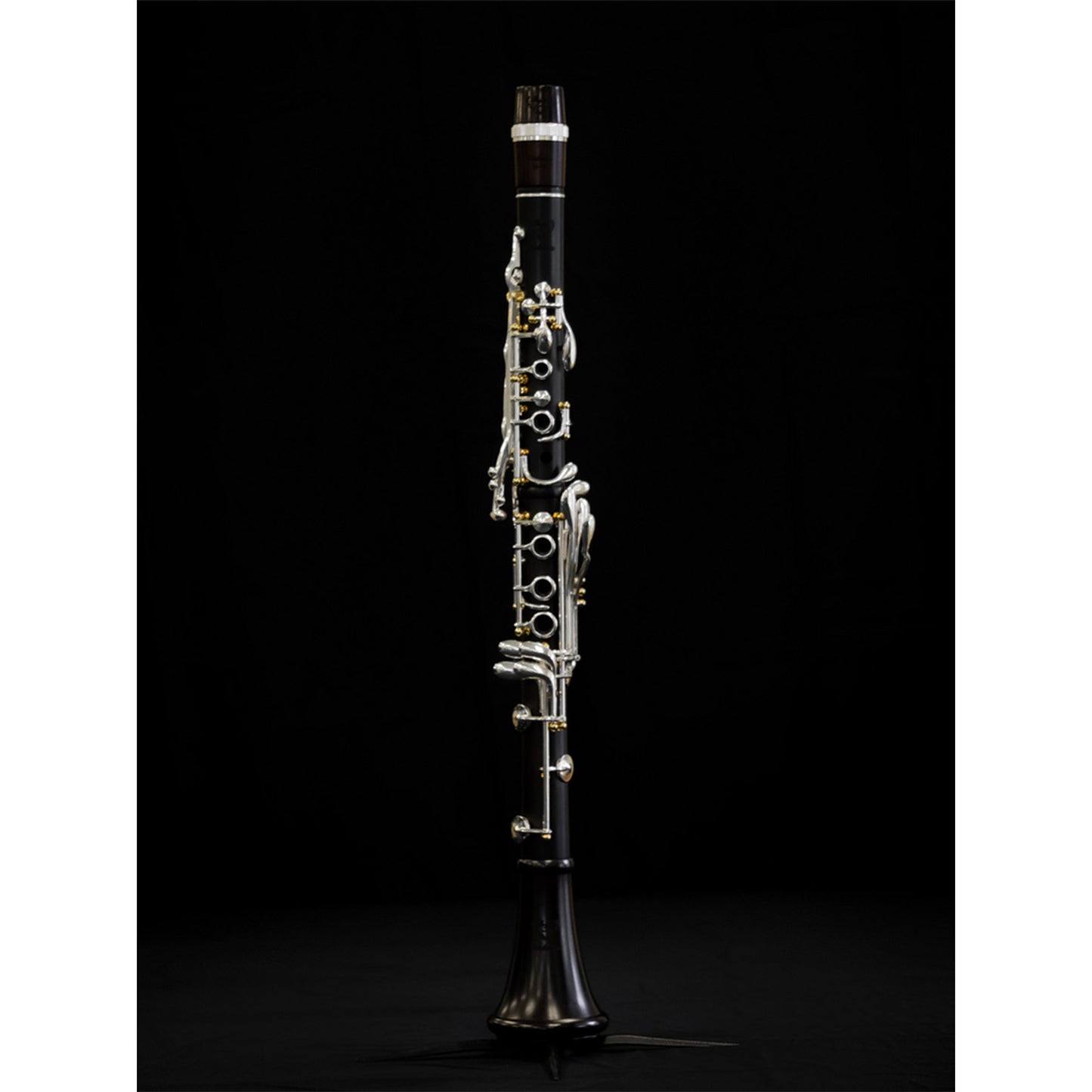 Full length front shot of assembled Polaris clarinet on stand, against black background